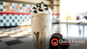 Thick Oreo milkshake topped with whipped cream and crushed cookies in a retro diner setting.